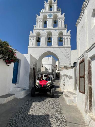 Couple driving a Buggy in the narrow streets of Pyrgos in Santorini